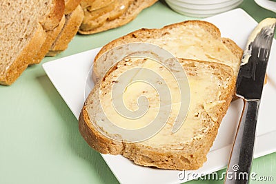 Bread and butter on square white plate Stock Photo