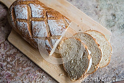 Bread slice on a wooden board. Wheat fresh loaf Stock Photo