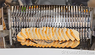 Bread slicing machine, freshly baked loaf sliced Stock Photo