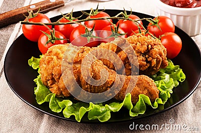 Breaded chicken legs with tomatoes Stock Photo