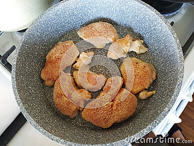 Breaded chicken pieces are fried in a pan Stock Photo