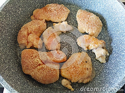 Breaded chicken pieces are fried in a pan Stock Photo