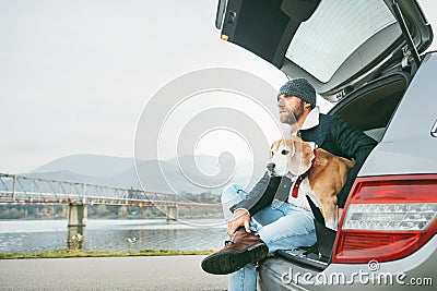 Breaded man in warm casual autumn outfit siting with beagle in c Stock Photo