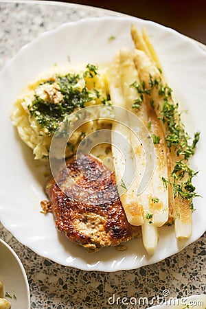 Breaded pork chops with white asparagus and mashed potatoes Stock Photo