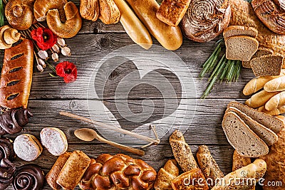 Breads, pastries, christmas cake on wooden background with heart, picture for bakery or shop, valentines day Stock Photo