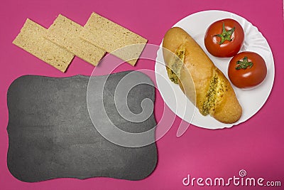 Breadstones on a pink background, a plate with a sandwich and tomatoes, a signboard, a breakfast for the child in school Stock Photo