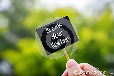 Break Your Routine. Hand Holding Stick Blackboard Stock Photo