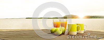 Breakfast of apples, orange juice and hot drink at sunrise Stock Photo