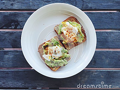 Breakfast: avocado toast with poached egg and chili flakes Stock Photo