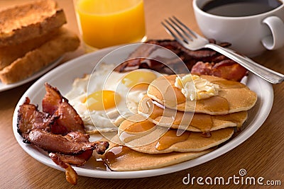 Breakfast with bacon, eggs, pancakes, and toast Stock Photo