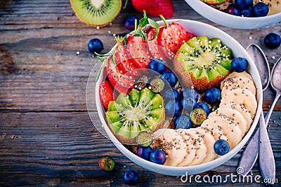 Breakfast bowl: granola with banana, kiwi, strawberry, blueberries and chia seeds Stock Photo