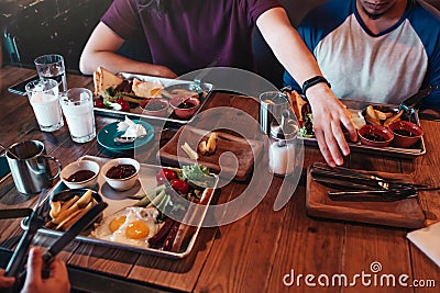 Breakfast in cafe. Friends eat breakfast in cafe. Young men are about to start their food and drinks. Stock Photo