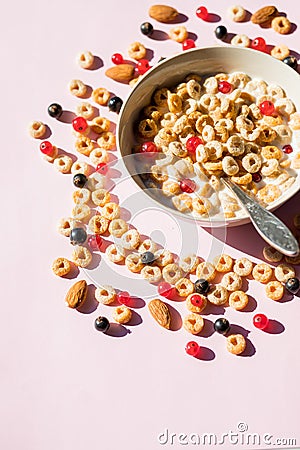 Breakfast cereals rings in a white bowl. Oatmeal, corn flakes on a pink background. Breakfast or brunch buffet in a hotel or Stock Photo