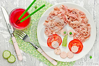 Breakfast for child. Pink noodles with sausage tomato cucumber a Stock Photo