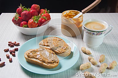 Breakfast with coffee and sandwiches with peanut paste and strawberries Stock Photo