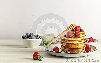 Breakfast concept with american pancakes with raspberries, blueberries, and honey Stock Photo