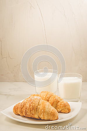 Breakfast with croissants and glasses milk/fresh croissants and glasses of milk on a white background. Selective focus Stock Photo