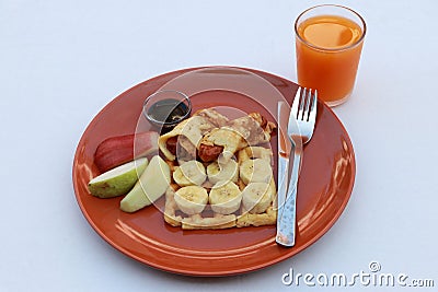 Breakfast in the dark orange color of round plate on the white floor. Dough roll and banana on the waffle and fruit rose apple, Stock Photo