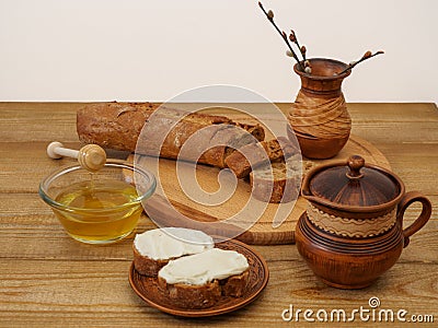 Breakfast in earthenware on a wooden table. Rustic natural products, baguette, honey, milk in a handmade clay jug Stock Photo