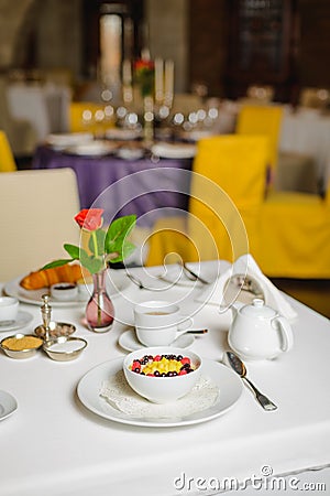 Breakfast in empty restaurant. Milk porridge with fruits. Stock Photo