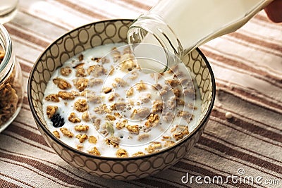 Breakfast food background. Milk Pouring Over Granola on light table napkin, Healthy vegetarian breakfast. Diet Nutrition Concept Stock Photo