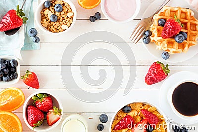 Breakfast frame of fruits, cereal, waffles, yogurt, milk and coffee. Top view over a white wood background. Stock Photo