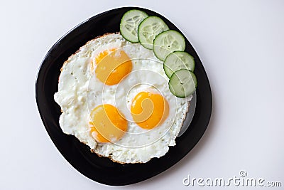 Breakfast. Fried eggs with bread and cucumbers Stock Photo