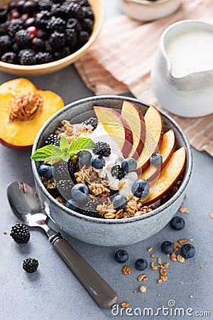 Breakfast granola bowl with yogurt, peach and berries Stock Photo