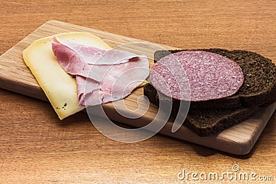 Breakfast or lunch setting with ham cheese an brown sandwich bread on wooden board Stock Photo