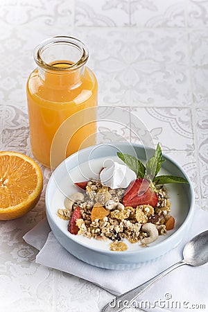 Breakfast. Muesli with milk or yogurt, nuts and strawberries, orange juice and orange Stock Photo