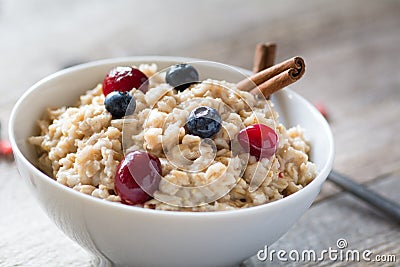 Breakfast oatmeal porridge with cinnamon, cranberries and blueberries Stock Photo