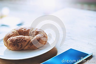 Breakfast at office with croissant and smart phone Stock Photo