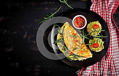 Breakfast. Omelette with tomatoes, cheese, green arugula and toasts with avocado cream Stock Photo