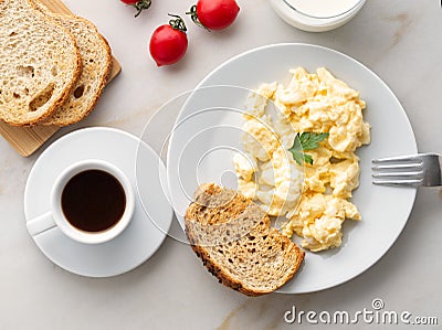 Breakfast with pan-fried scrambled eggs, cup of coffee, tomatoes on white stone background. Omelette, top view Stock Photo