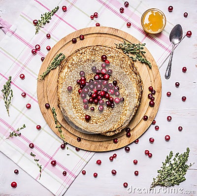 Breakfast with pancakes and honey, berries, cranberries and thyme tea wooden rustic background top view Stock Photo