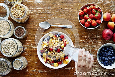 Breakfast scene hand pouring milk on muesli healthy lifestyle organic nutrition Stock Photo