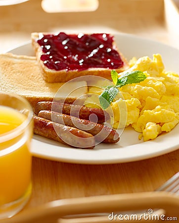 Breakfast with scrambled eggs, sausage links and toast. Stock Photo