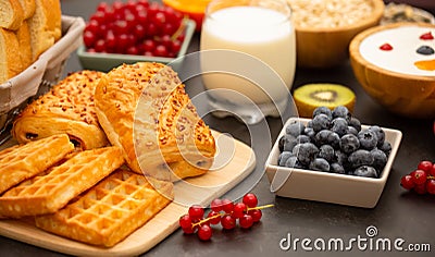 Breakfast Served in the morning with Butter bread and corn flakes Whole grains and raisins with milk in cups and Strawberry, Blueb Stock Photo