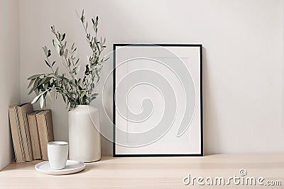 Breakfast still life. Cup of coffee, books and empty picture frame mockup on wooden desk, table. Vase with olive Stock Photo