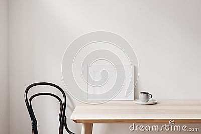 Breakfast still life scene. Cup of coffee, books and empty horizontal white picture frame mockup on wooden table Stock Photo