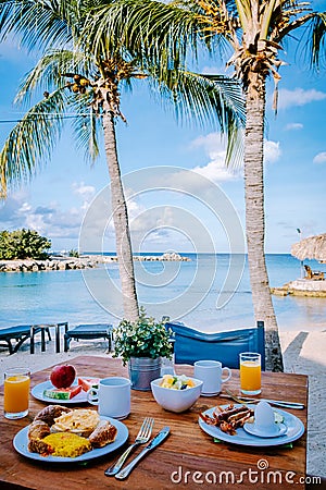 breakfast on a table by the beach looking out over the ocean, Caribbean sea with breakfast table with coffee orange Stock Photo