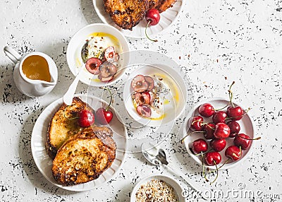 Breakfast table. Greek yogurt with cherries and honey and caramel french toast on white table, top view. Flat lay. Summer breakfas Stock Photo