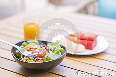 Breakfast. Vegetable salad, fruits such as watermelon, papaya, melon, passion fruit, orange juice and coffee. placed on a gray Stock Photo