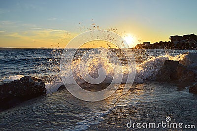 Breaking waves at sunset Stock Photo