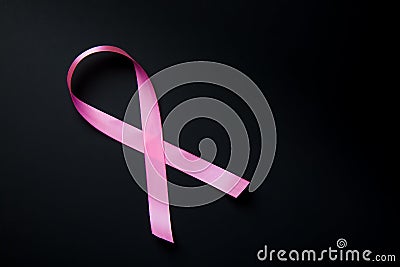 Breast Cancer concept. Pink ribbon symbol of breast cancer on black background. Stock Photo