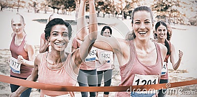 Breast cancer participants crossing finish line at race Stock Photo