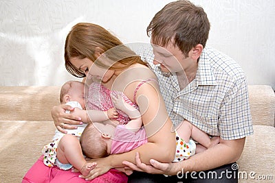 Breast feeding two little sisters twin Stock Photo