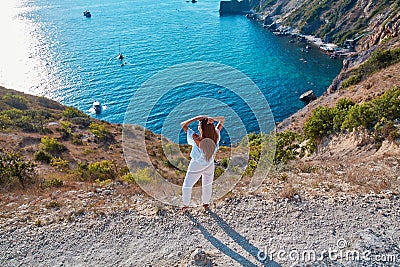 Breathtaking scenic view of rocks and sea. Woman enjoying amazing summer landscape. Time to travel. Summer travelling Stock Photo