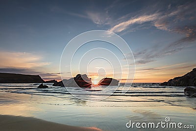 Breathtaking sunrise with emphasized rays spreading light and warmth in Atlantic Coast, Cornwall, UK Stock Photo