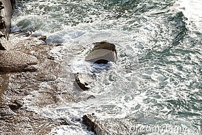 Breathtaking view of powerful waves crashing against rugged rocks in a stunning landscape. Stock Photo